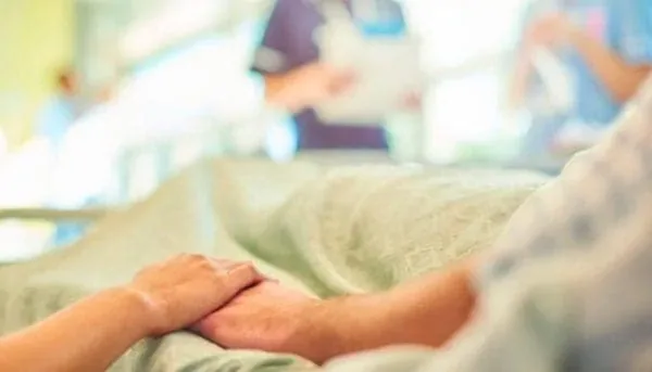 Caregiver holding a patient's hand