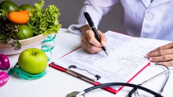 Doctor writing a medical weight loss plan