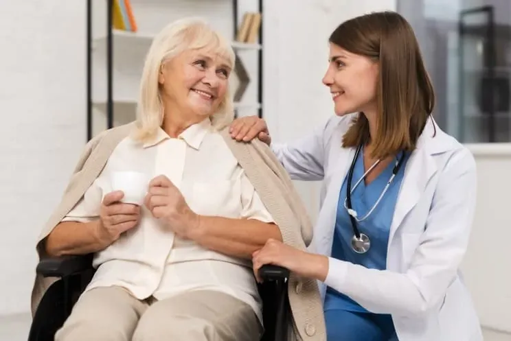Caregiver talking with a smiling senior resident
